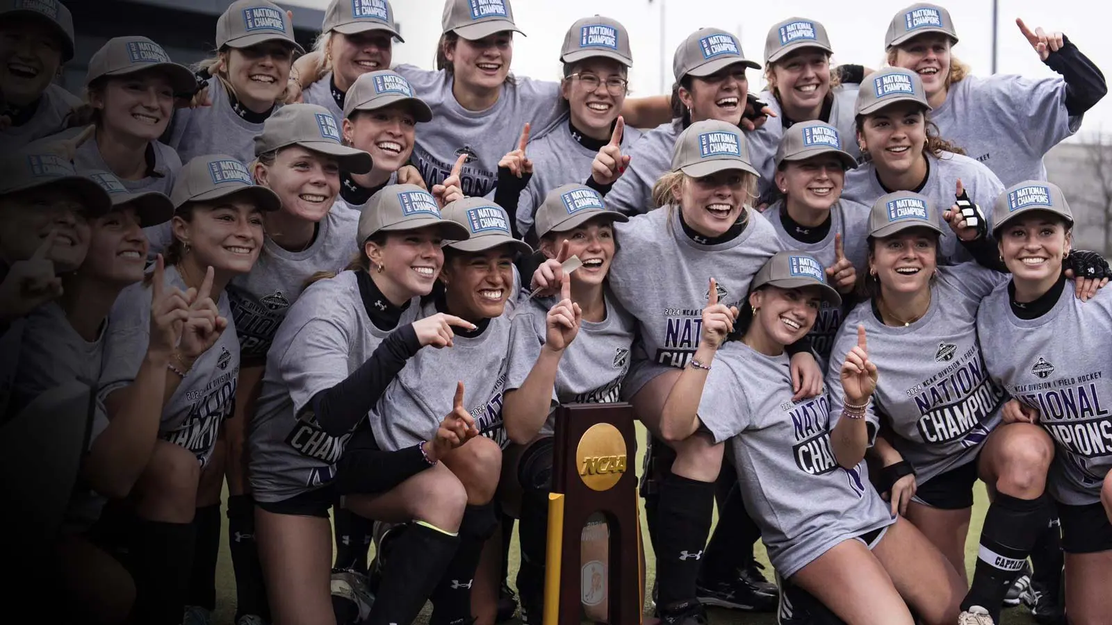 Women's basketball players holding a trophy on the court